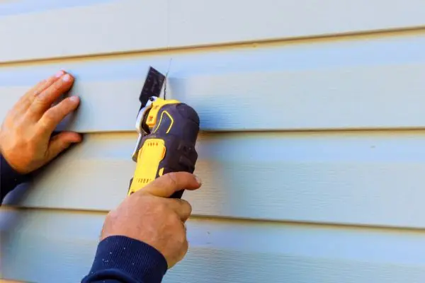 damaged vinyl siding of house was removed using a multi tool