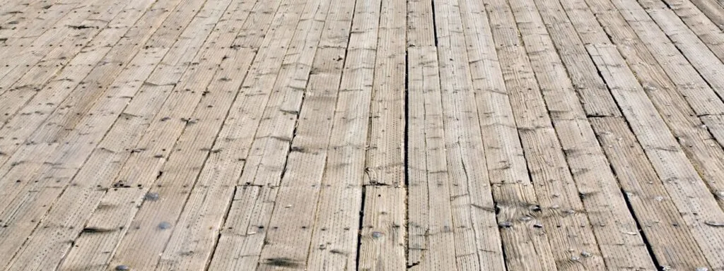 close up image of old wood deck with damage