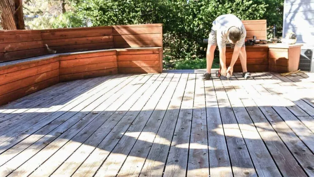 a man doing maintenance on old deck